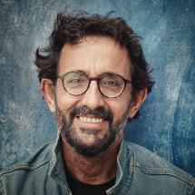 image of a man with a beard wearing glasses in a jean jacket